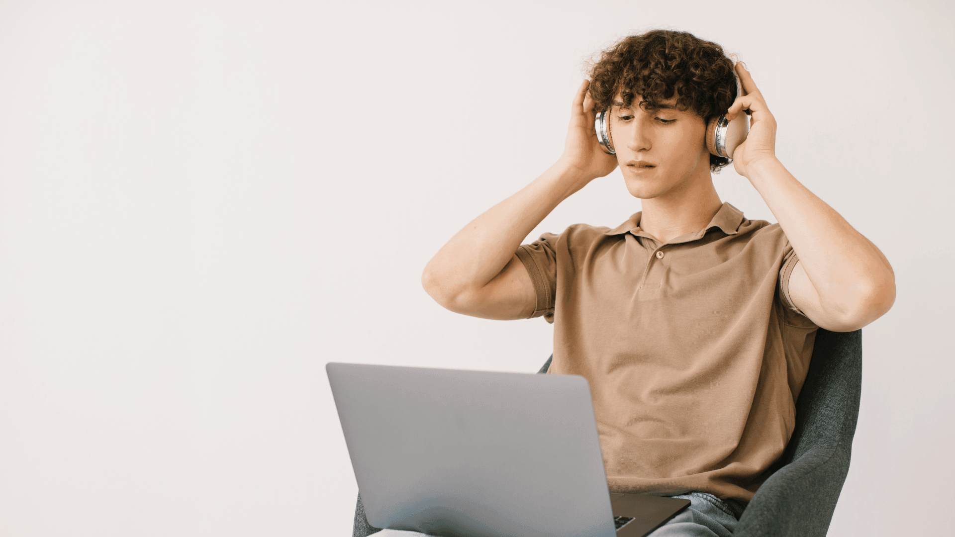 Man with headphones focusing on his laptop during an online therapy session for ADHD