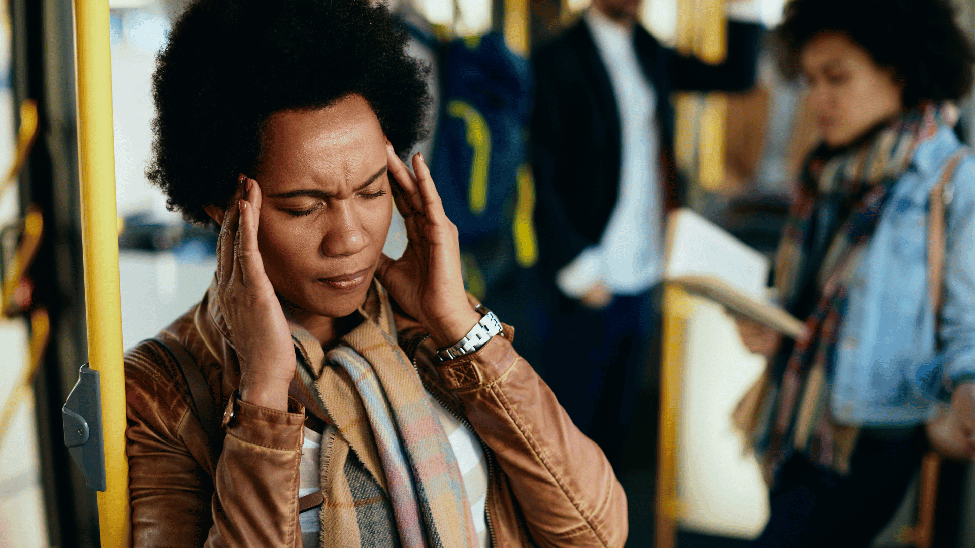 Woman sitting at a desk with her hands on her forehead, looking overwhelmed, signifying daily stress