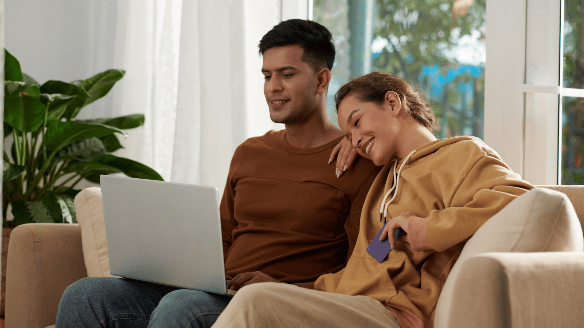 Happy couple participating in online therapy from their couch