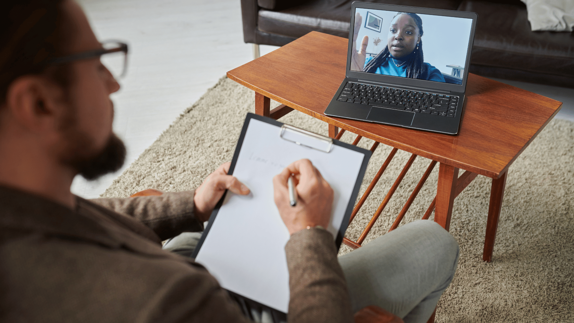 Therapist taking notes during an online CBT session