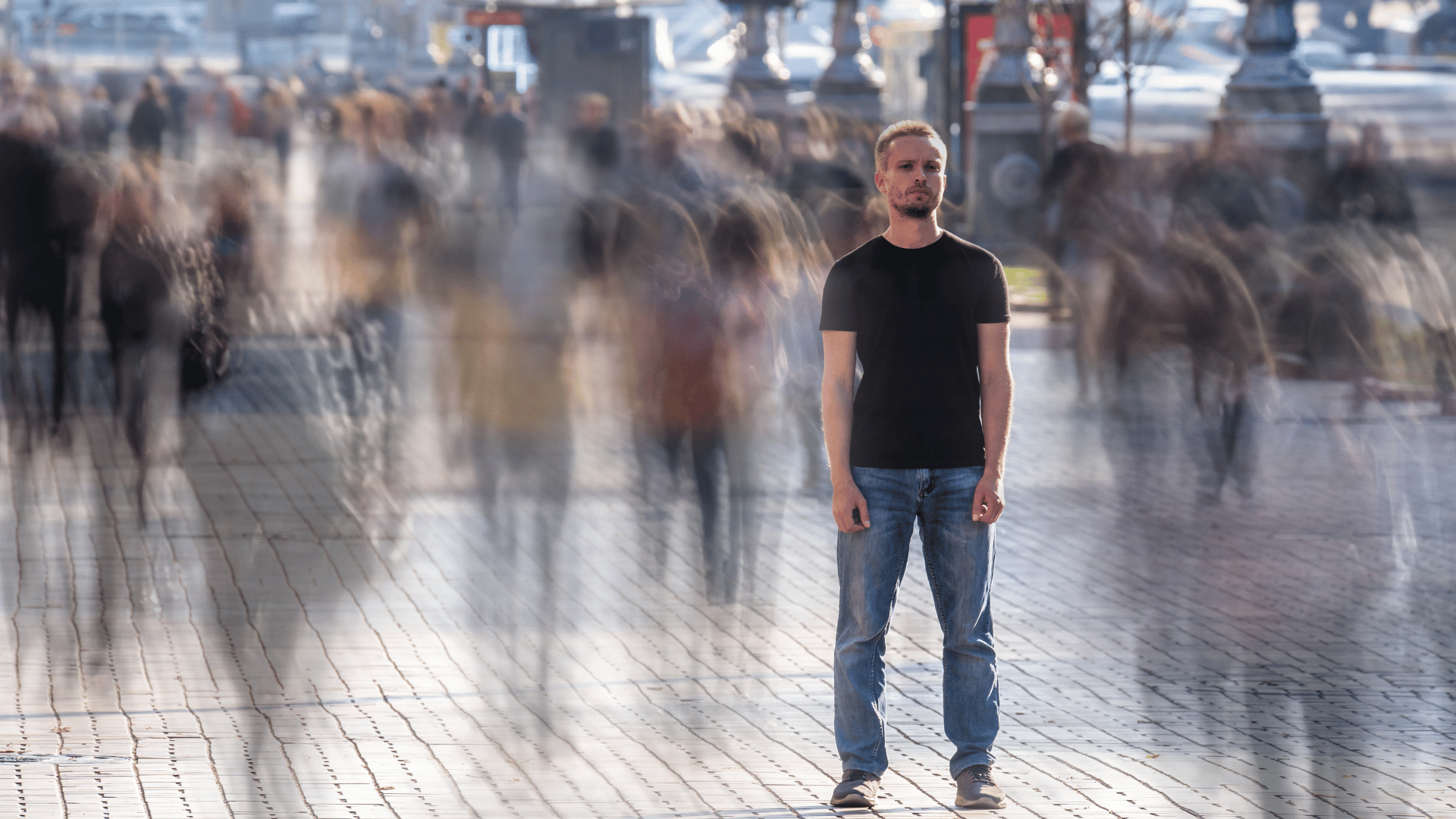 Person standing still amidst a blurred crowd, representing the experience of OCD